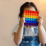 Detailed view of the rainbow-colored fidget toy, emphasizing its unique shape and vibrant colors